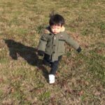芝生の斜面を走る1歳児