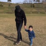 父親と芝生の上を歩く1歳児