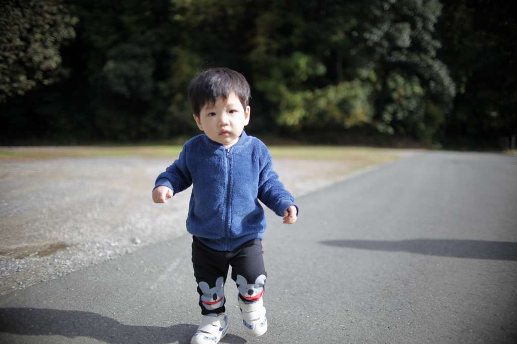 靴を履いて歩く1歳児