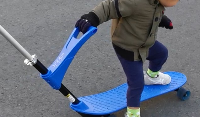 スケートボードに片足を乗せて乗ろうとしている2歳児