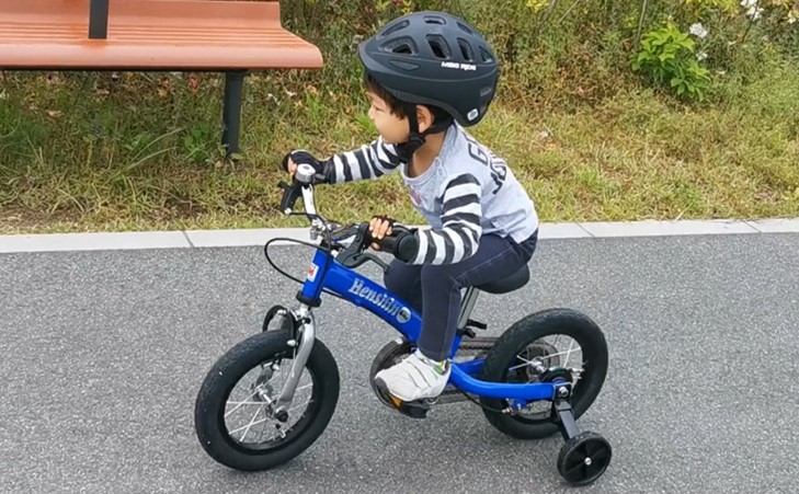 補助輪付自転車で走る子供